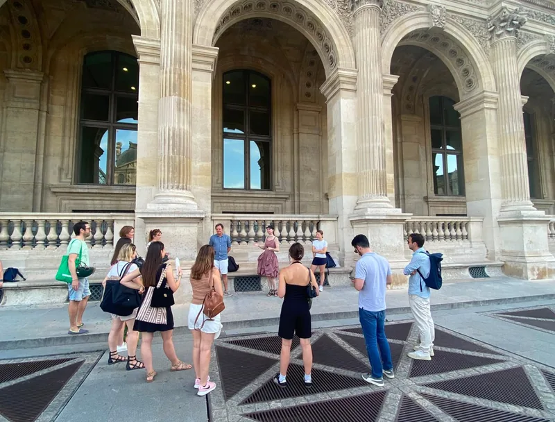 Groupe de collaborateurs en team building INDY GAMES devant les arcades du Louvre à Paris